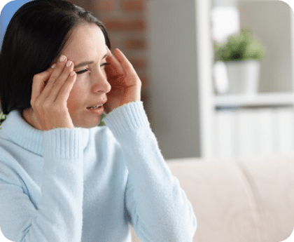 Woman touching her temple with a pained expression suggesting a headache