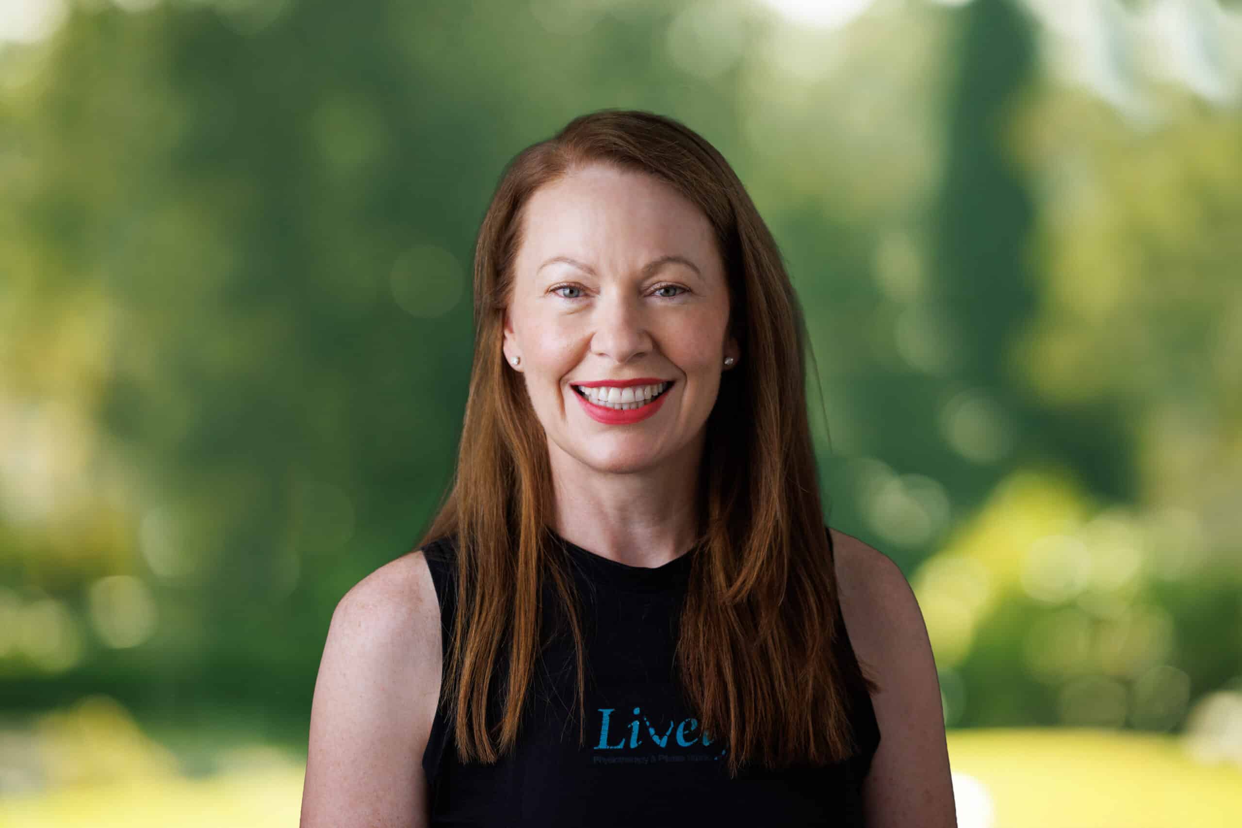 Julie Vawdrey, team member at Lively Physio, smiling outdoors in a black Lively Physio top