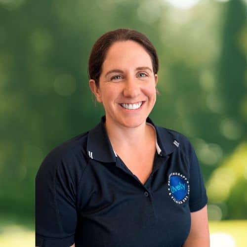 Sarah Gartside, physiotherapist at Lively Physio, smiling outdoors in a navy Lively Physio polo shirt
